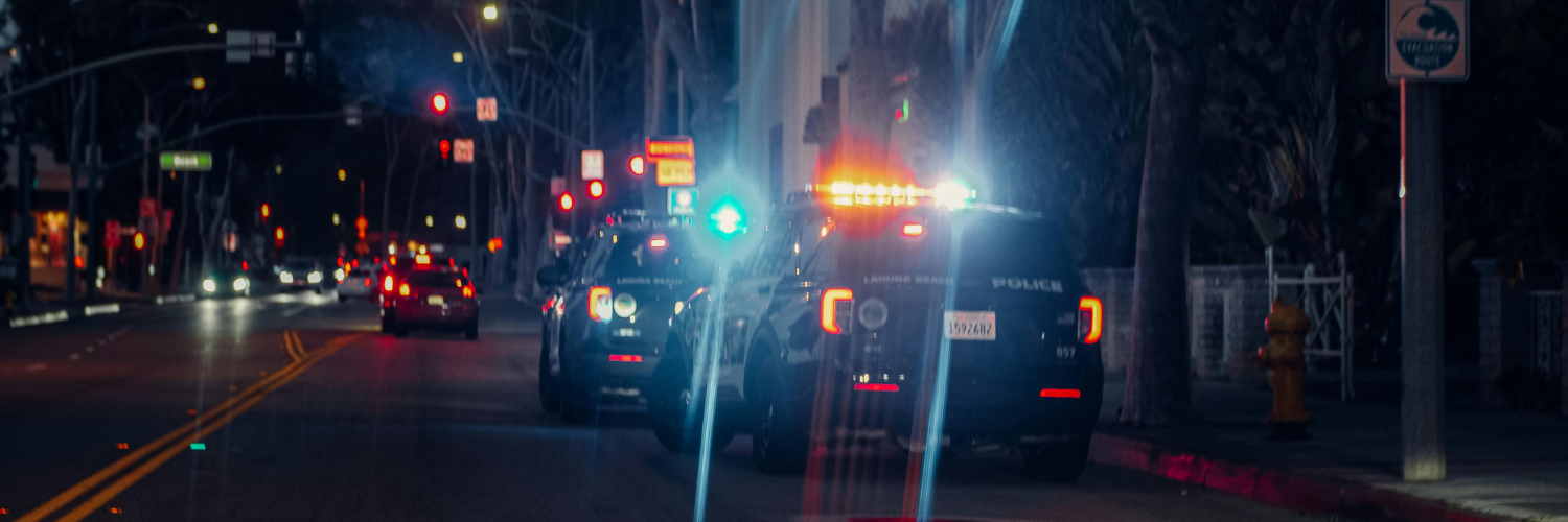 Police cars at night with flashing lights, representing a traffic stop or ticket